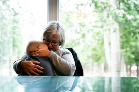 A grandmother holding her grandchild.